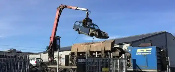 Skrotbil parkerad vid uppfart där tydlig information, kompletta delar och enkel hämtning påverkar ersättningen vid försäljning.