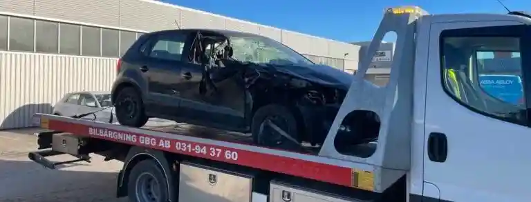 Bil på bilskrot där delar demonteras och material förbereds för återvinning.